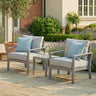 Grey outdoor garden armchair set with blue cushions and side table on stone patio