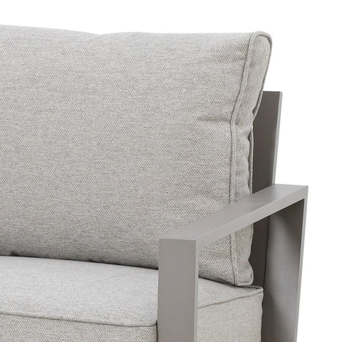 Close view of grey fabric armchair with metal armrest and plush back cushion