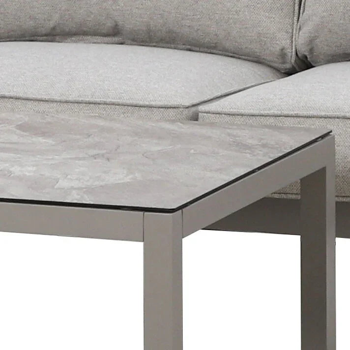 Grey sofa corner with textured seat cushions and modern square coffee table