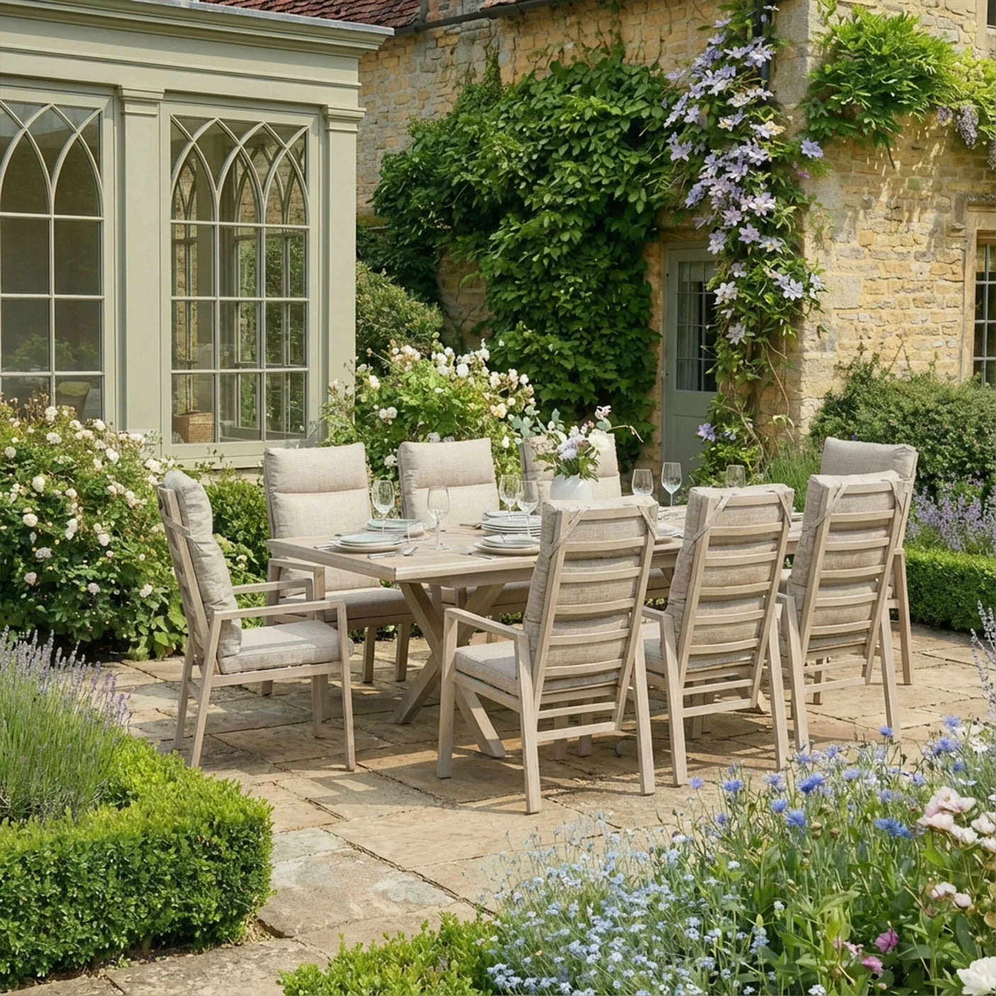 Outdoor dining set with eight cushioned wooden chairs and table on stone patio in garden