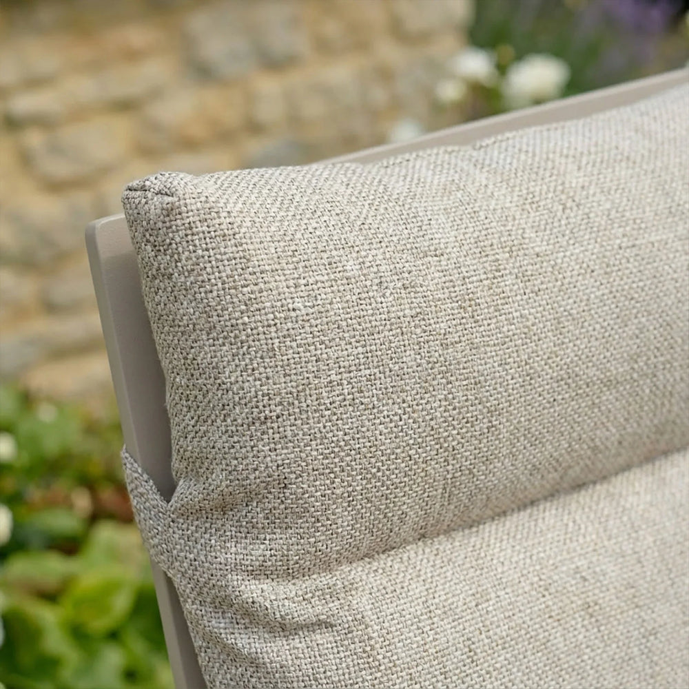 Close-up of beige outdoor furniture cushion with textured fabric on chair backrest