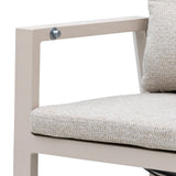 Beige metal armchair with textured cushion and matching pillow, close-up side view