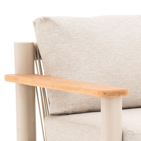 Beige fabric armchair with light wood armrest and metal frame closeup