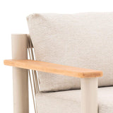 Beige fabric armchair with light wood armrest and metal frame closeup