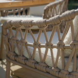Close view of woven rope outdoor dining chair with beige cushion and armrest detail