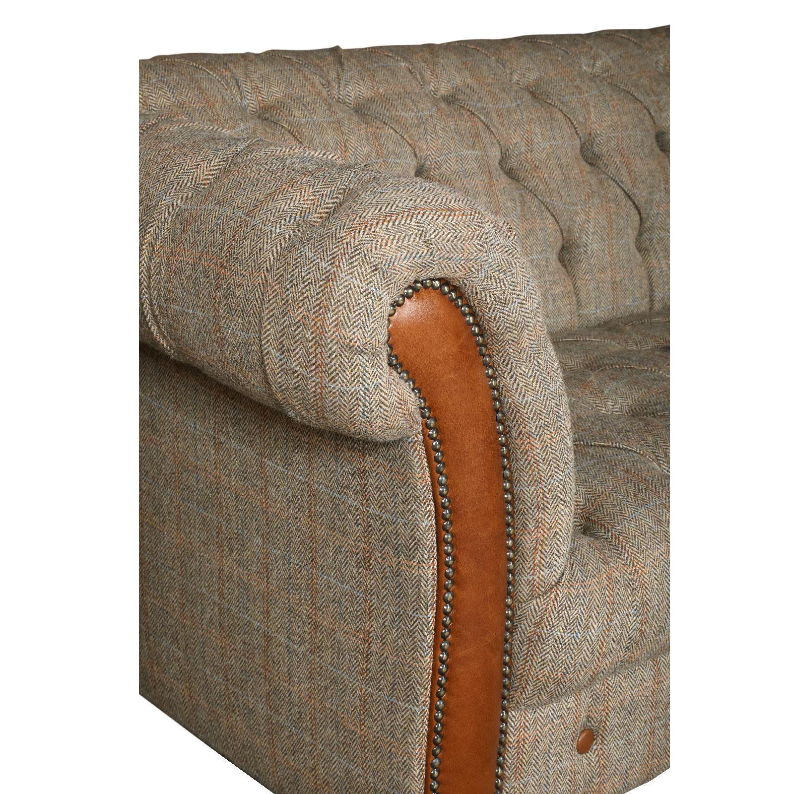 Herringbone fabric sofa arm with tan leather trim and button tufted upholstery detail