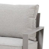 Closeup of grey fabric sofa with metal armrest and padded back cushion