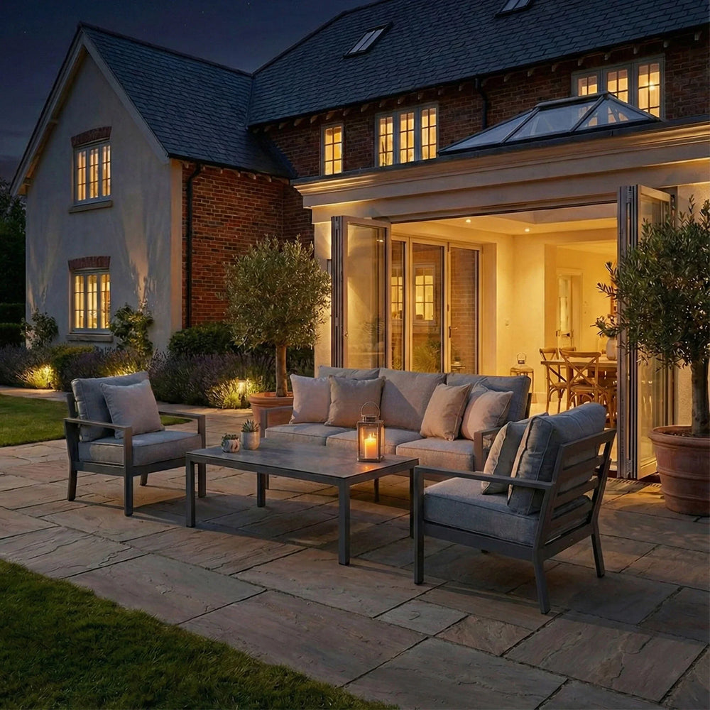 Grey outdoor sofa set with cushions and coffee table on patio at dusk