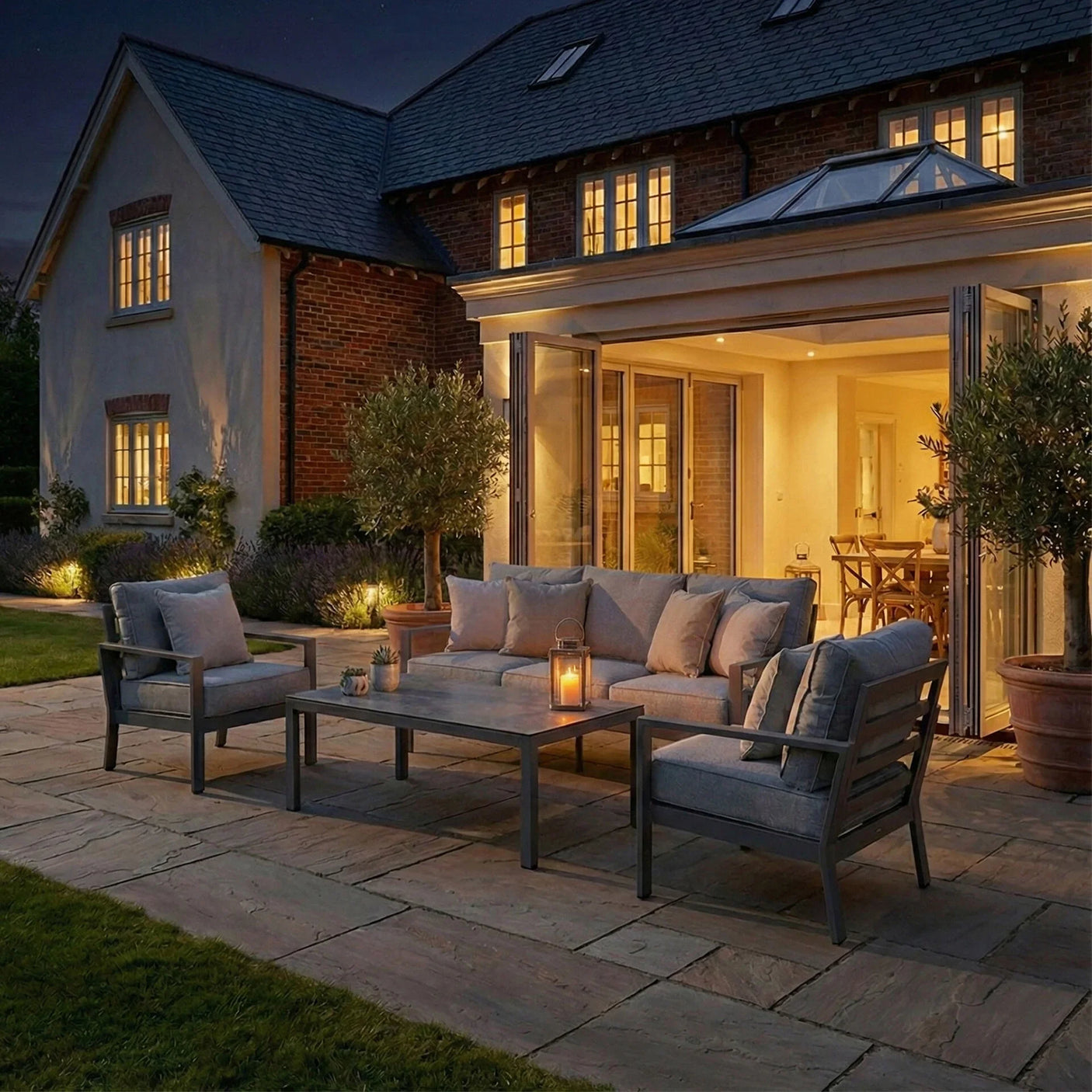 Grey outdoor sofa set with cushions and coffee table on patio at dusk
