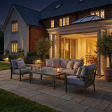 Grey outdoor sofa set with cushions and coffee table on patio at dusk