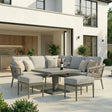 Grey outdoor corner sofa set with cushions and dining table on modern patio