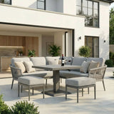 Grey outdoor corner sofa set with cushions, dining table and stools on modern patio
