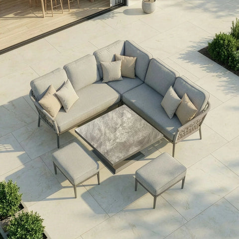 Grey outdoor corner sofa set with cushions, matching stools, and stone-effect coffee table on patio