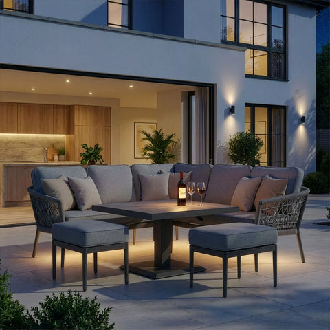 Grey outdoor corner sofa set with matching stools and rectangular table on patio at dusk