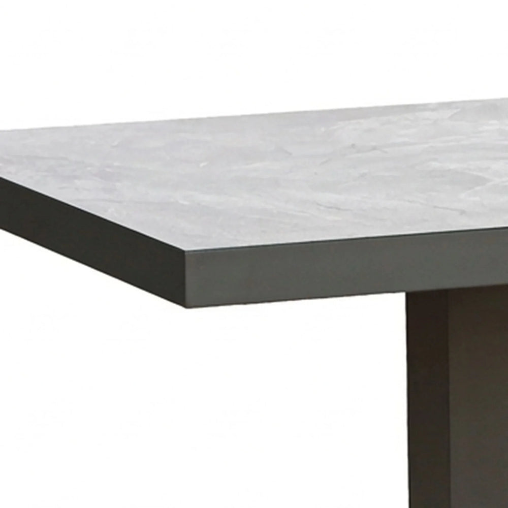 Grey stone effect dining table corner with black legs, modern rectangular design