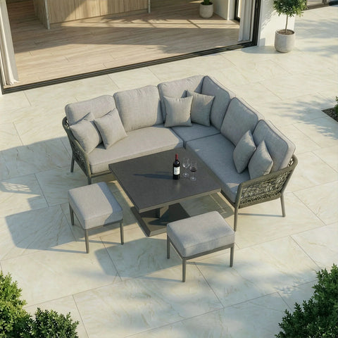 Grey outdoor corner sofa set with cushions, stools and dining table on patio