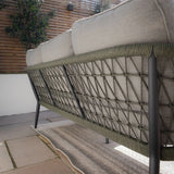 Back view of outdoor sofa with grey cushions and rope detail on black metal frame