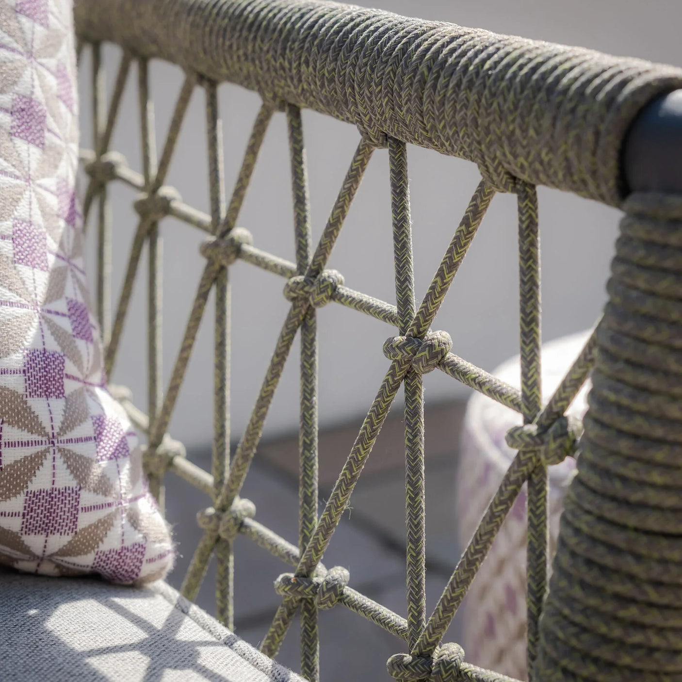 Close-up of outdoor sofa rope detail with geometric cushion on patio