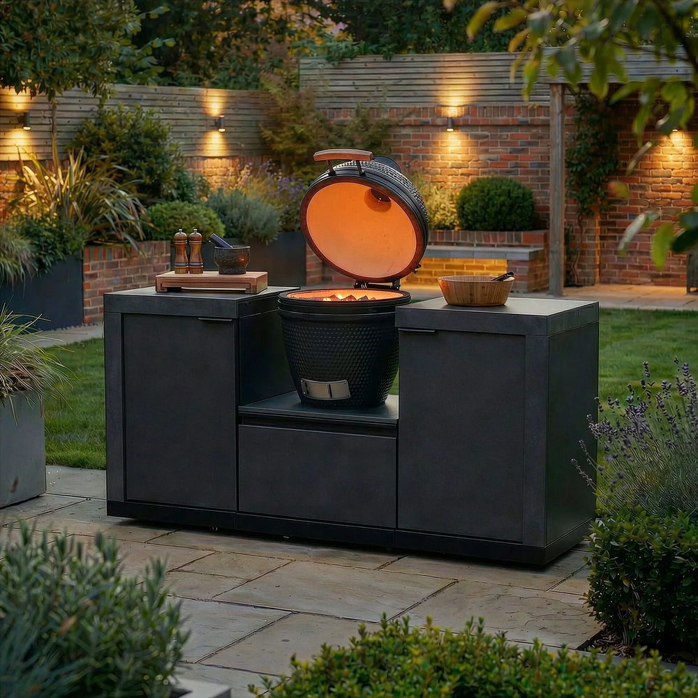 Outdoor ceramic charcoal barbecue grill with cabinets in landscaped garden setting