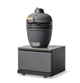 Black ceramic BBQ grill with temperature gauge on a metal rolling storage unit