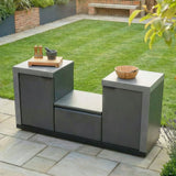 Outdoor kitchen island with grey cabinets on patio, wooden bowl and spice set on top