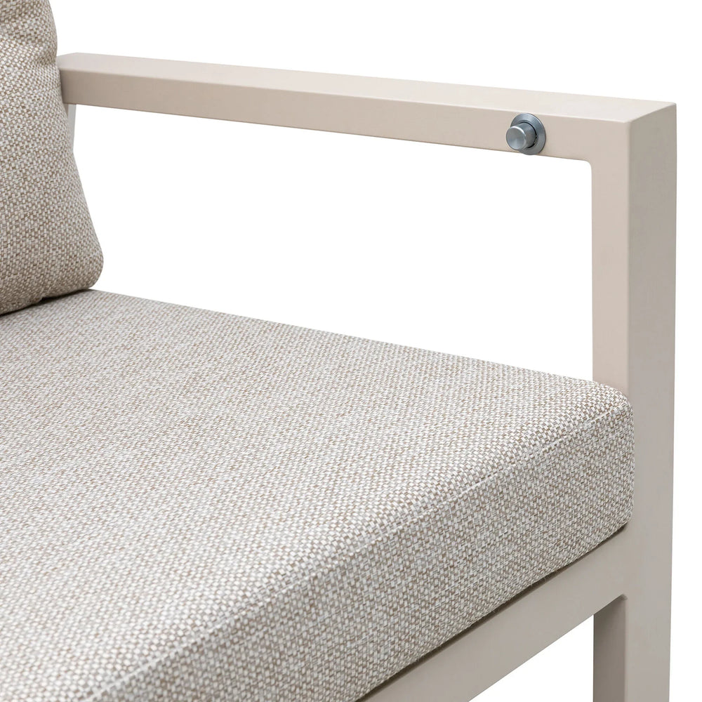 Beige fabric sofa seat cushion and metal armrest, close-up of upholstery texture