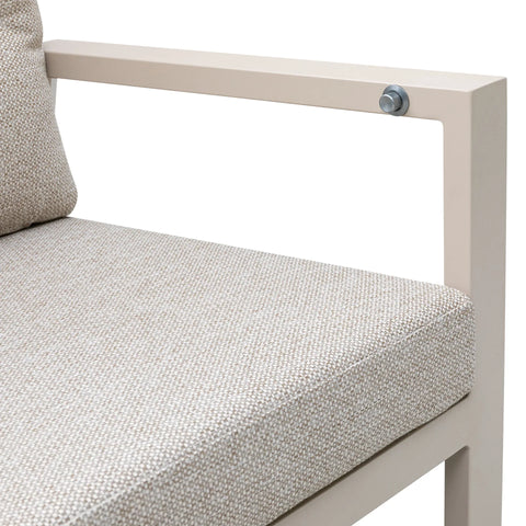 Beige fabric sofa seat cushion and metal armrest, close-up of upholstery texture