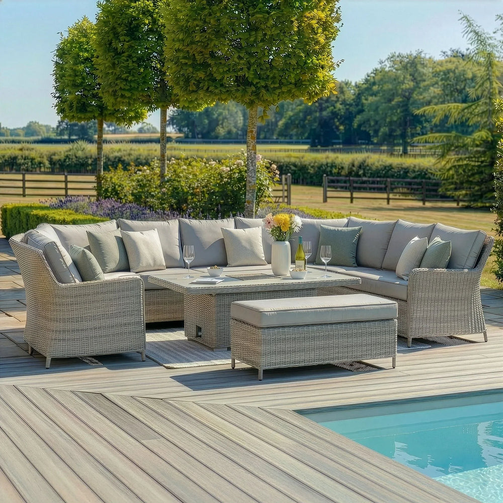 Grey rattan corner garden sofa set with cushions and dining table beside pool on patio decking