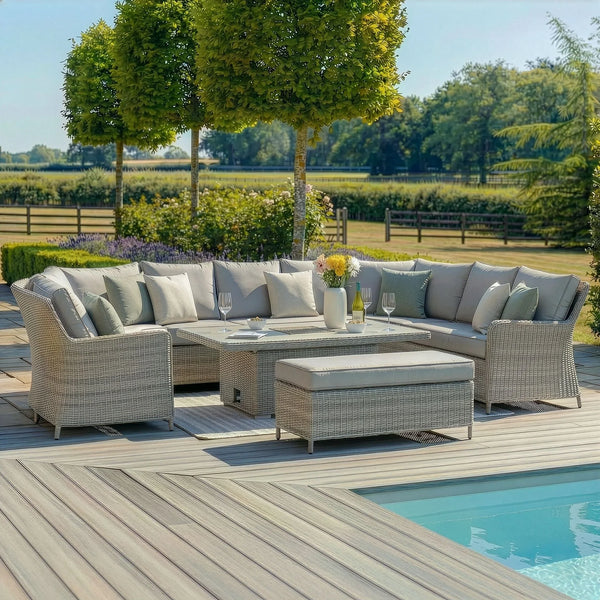 Grey rattan corner garden sofa set with cushions and dining table beside pool on patio decking