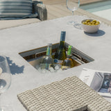 Outdoor dining table with ice bucket, wine bottles, glass, olives and wicker placemat