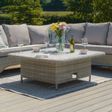 Rattan outdoor corner sofa set with grey cushions and matching dining table on patio