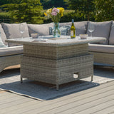 Grey rattan garden corner sofa with glass top table, wine, flowers, and outdoor rug