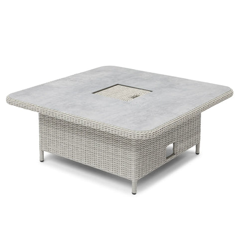 Square rattan outdoor dining table with grey stone-effect top and central cutout