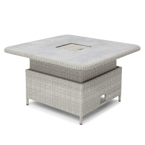 Square rattan outdoor dining table with grey stone-effect top and central cut-out feature