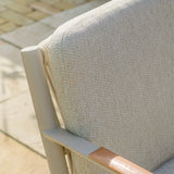 Close-up of outdoor chair with beige woven fabric backrest and metal frame on patio