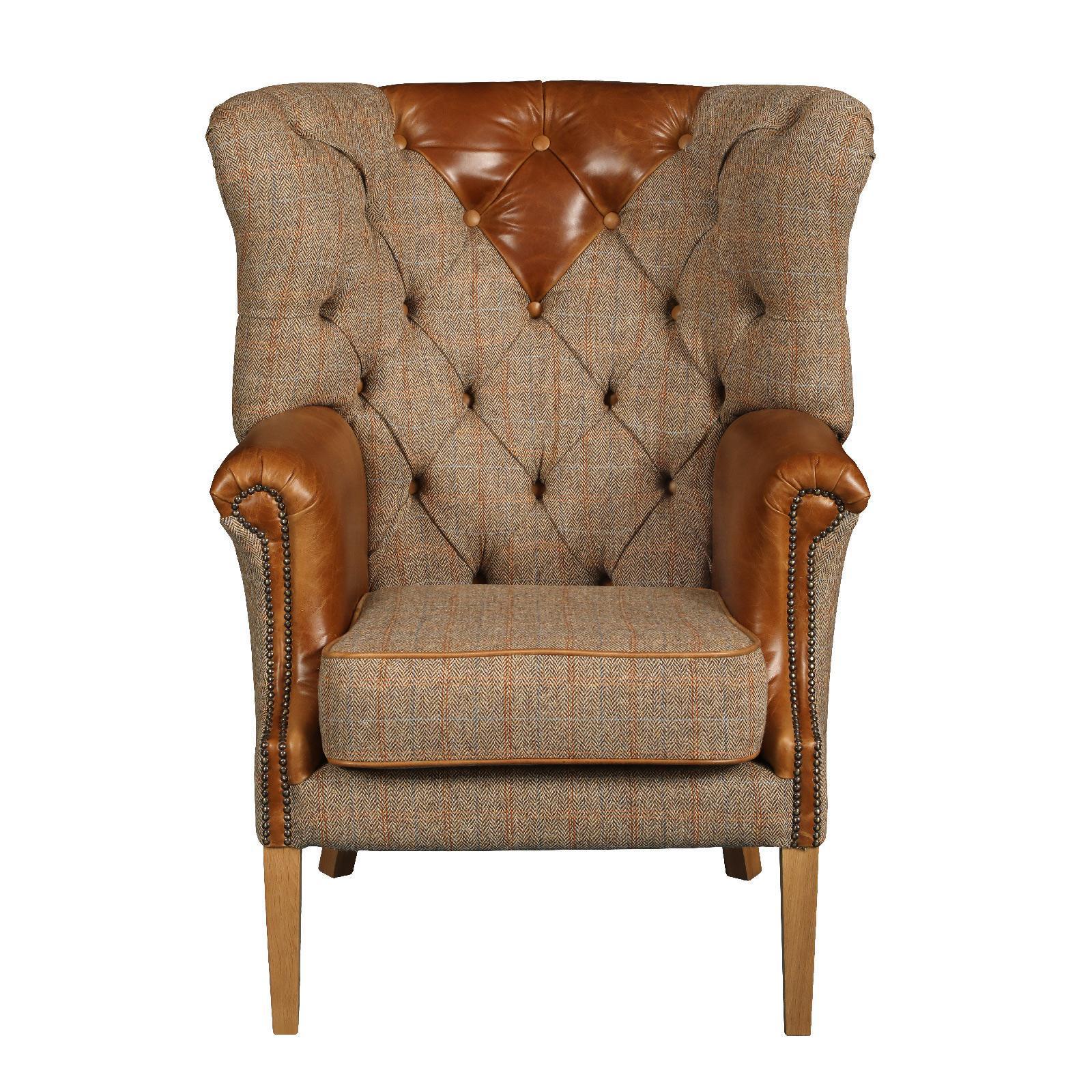 Wingback armchair with brown tweed upholstery and tan leather accents on arms and back
