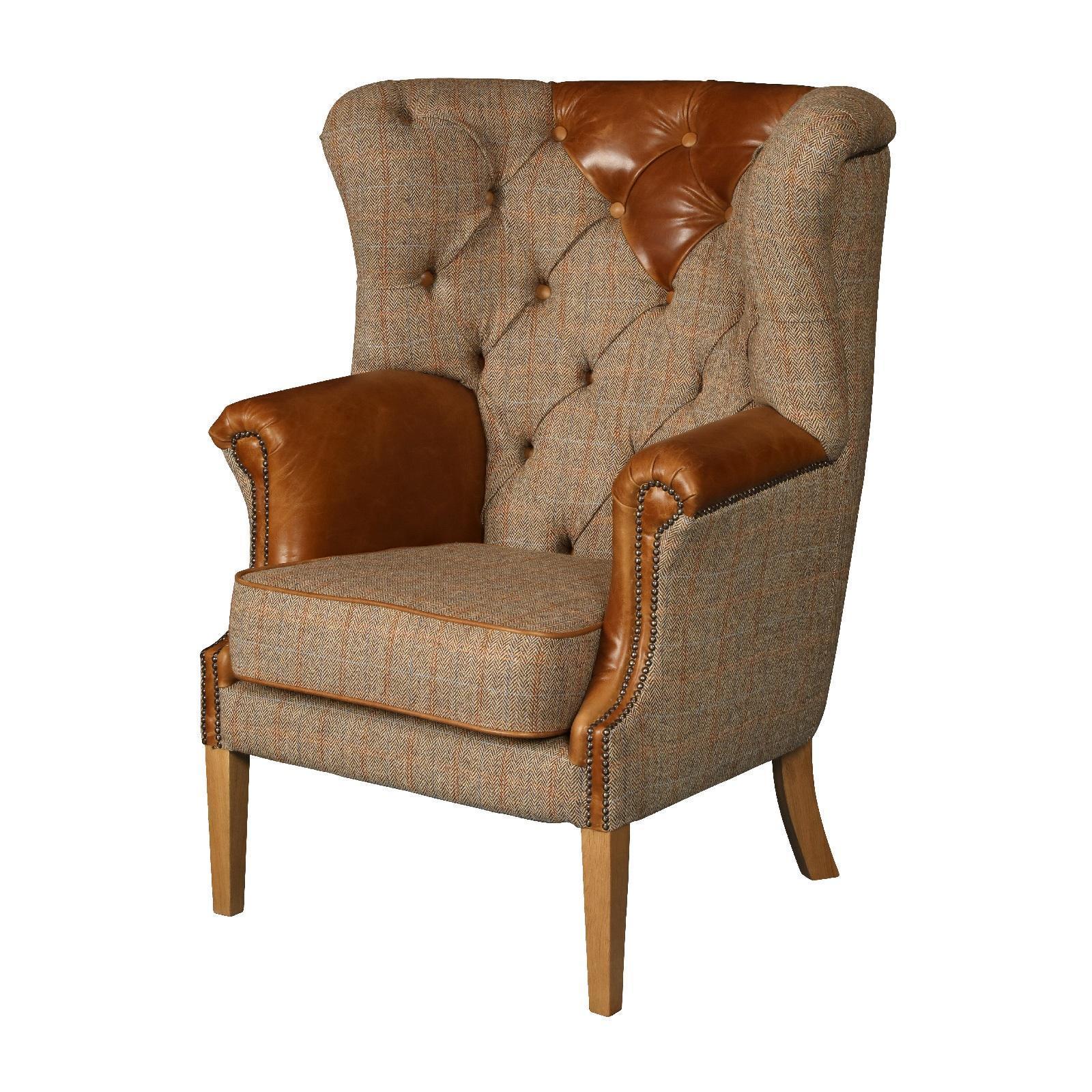 Brown tweed armchair with leather accents, button-tufted back, and wooden legs