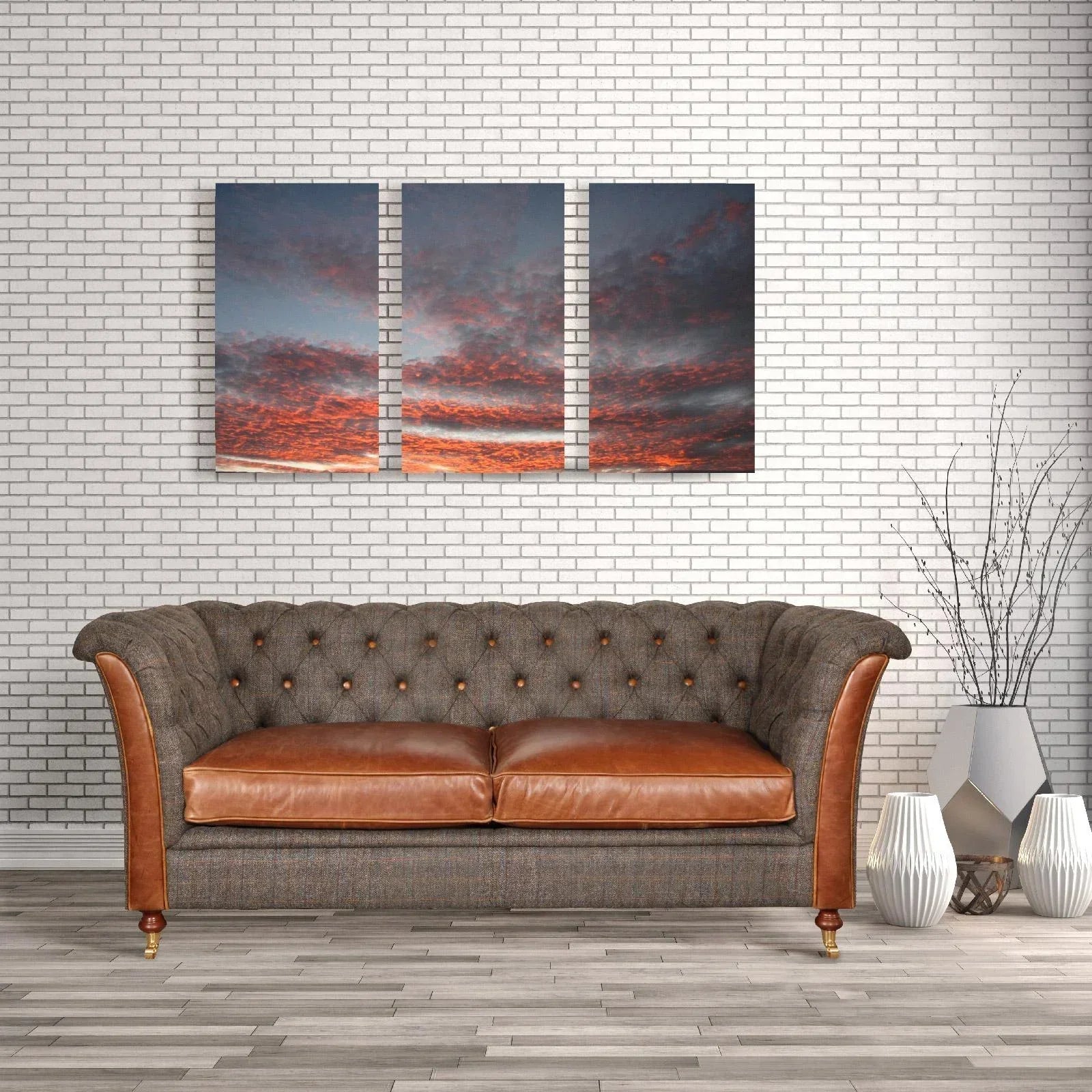 Brown leather and fabric sofa with button tufting in modern living room with wall art