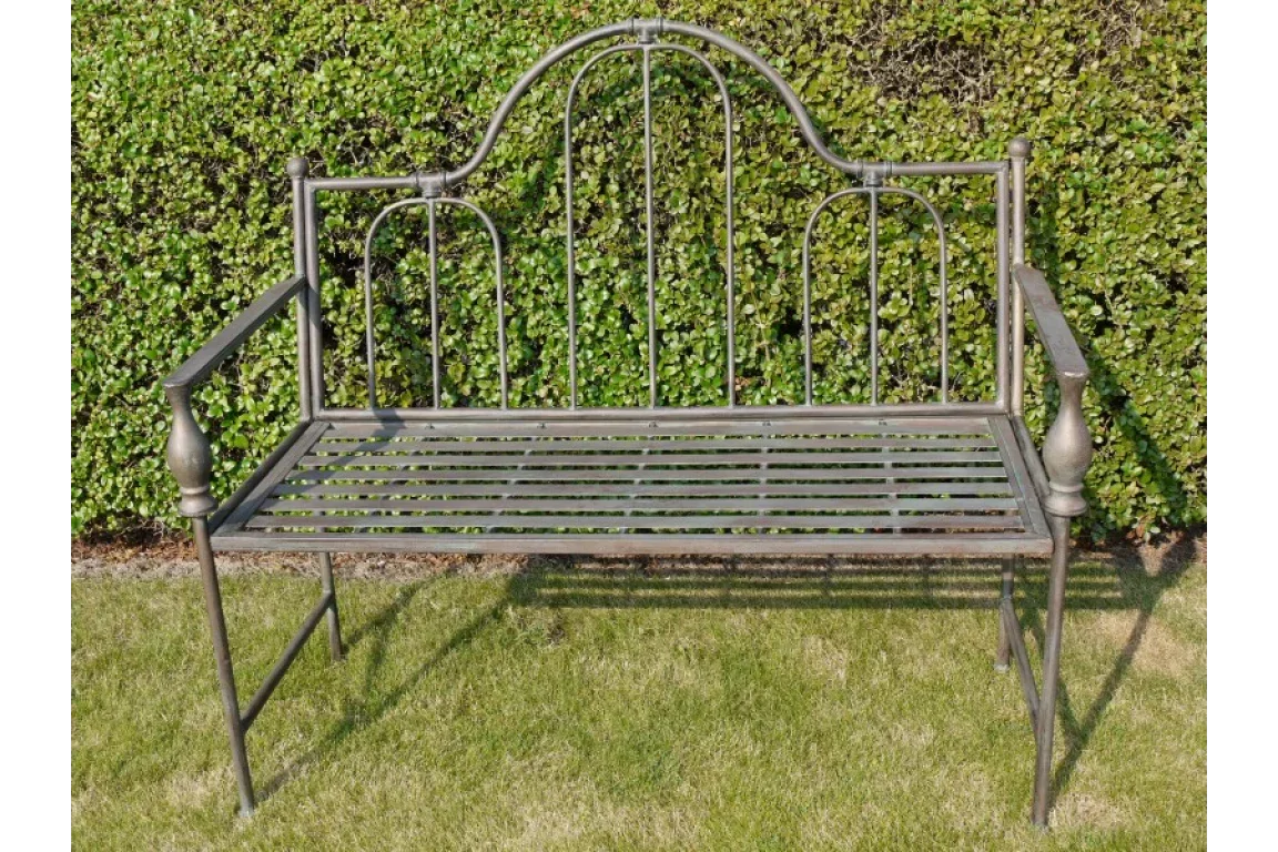 Metal garden bench with slatted seat and decorative backrest on lawn