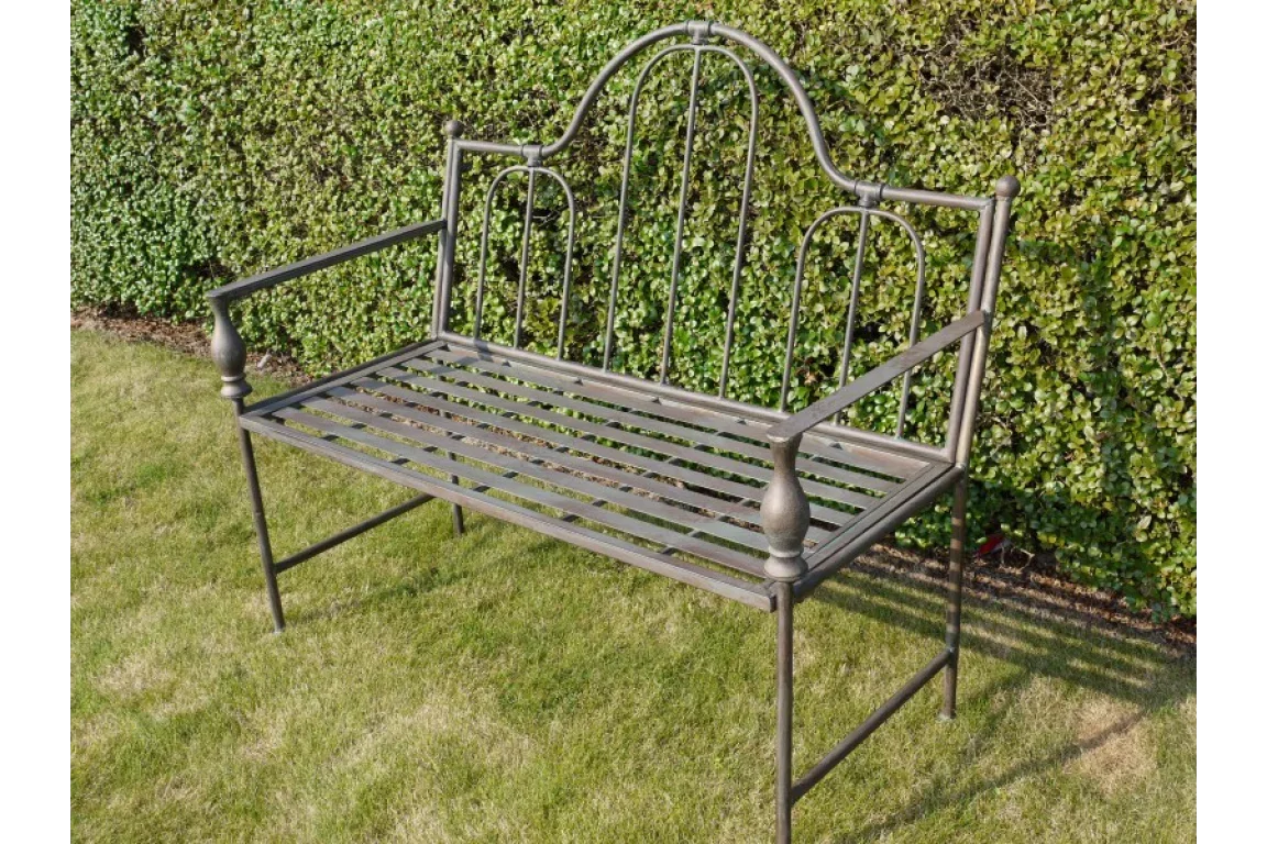metal garden bench with slatted seat and arched backrest on lawn