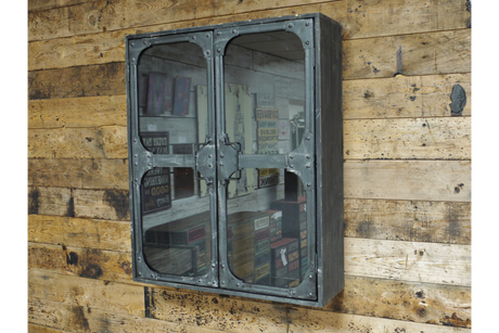 Metal wall cabinet with glass double doors, rivet details, mounted on rustic wooden plank wall, angled view.