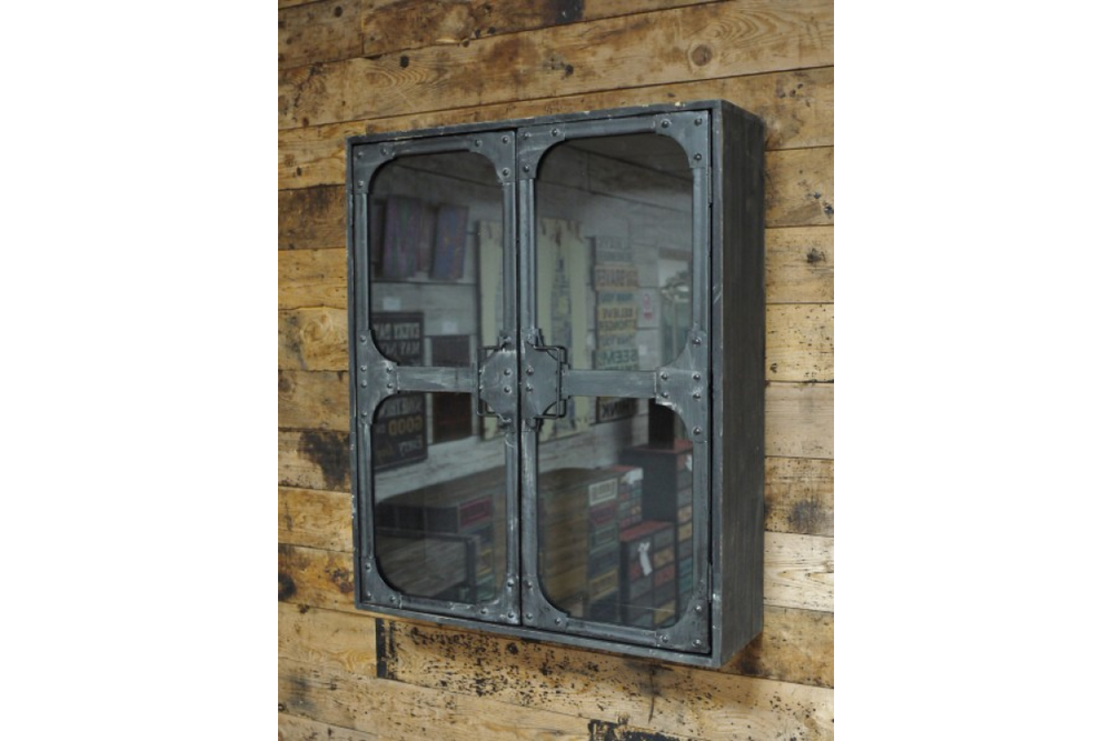 Wall-mounted black metal wall cabinet with two glass doors, viewed from a slight side angle against a wooden plank wall.
