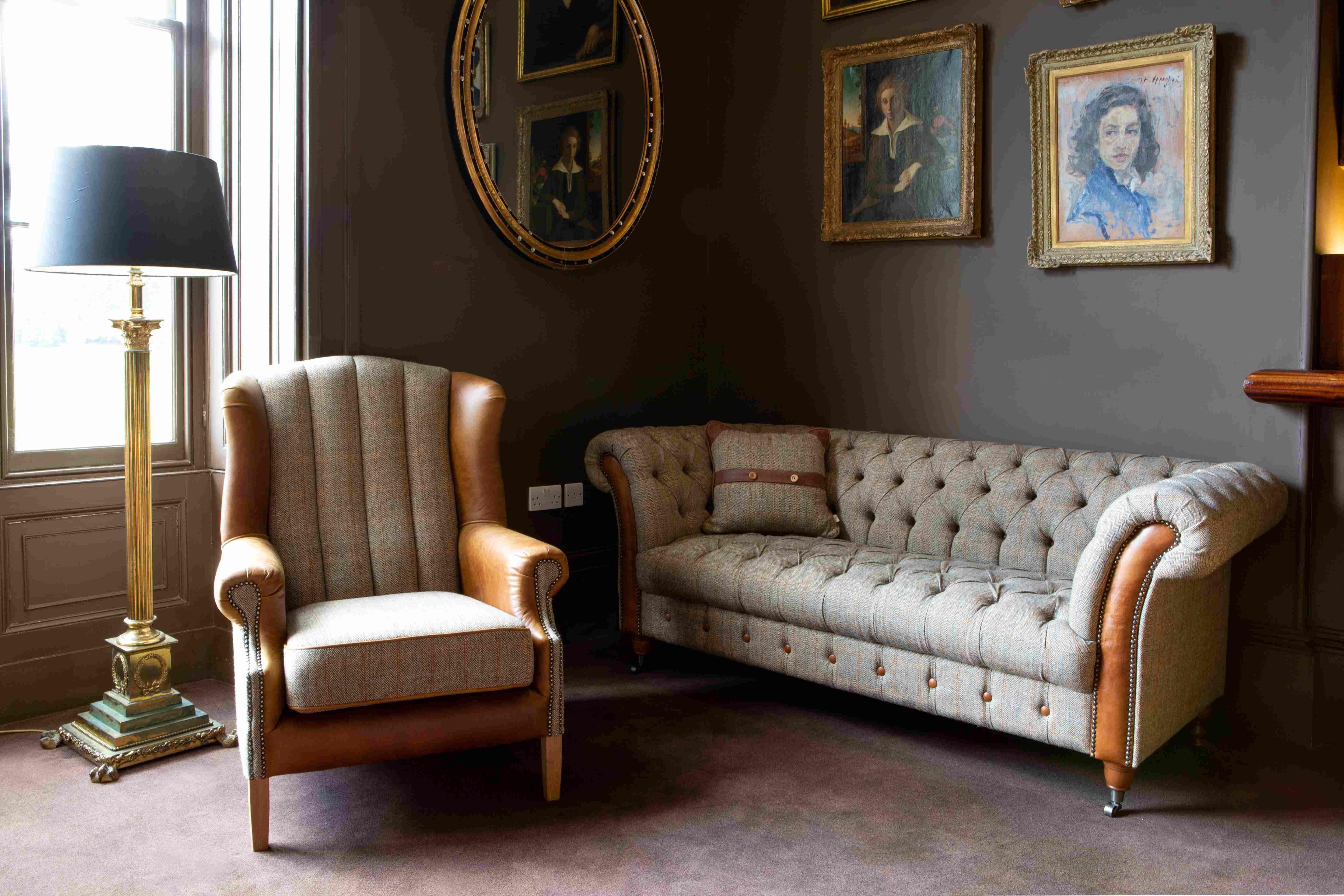 Button-tufted tweed sofa and armchair with leather trim in traditional living room
