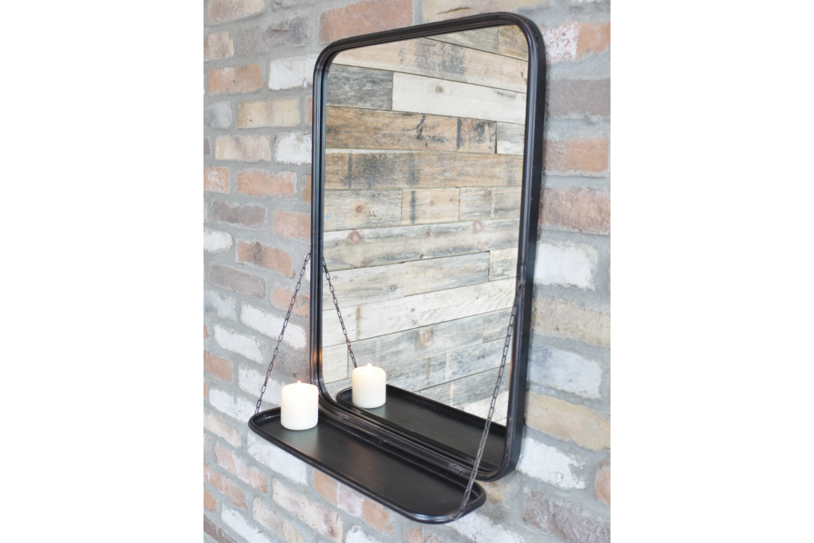 Rectangular black metal wall mirror with rounded corners and attached shelf holding a white candle.