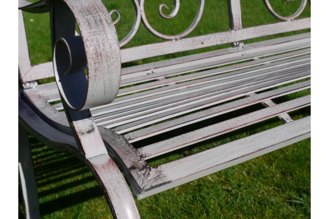Vintage metal garden bench with a distressed white finish and decorative armrest detail