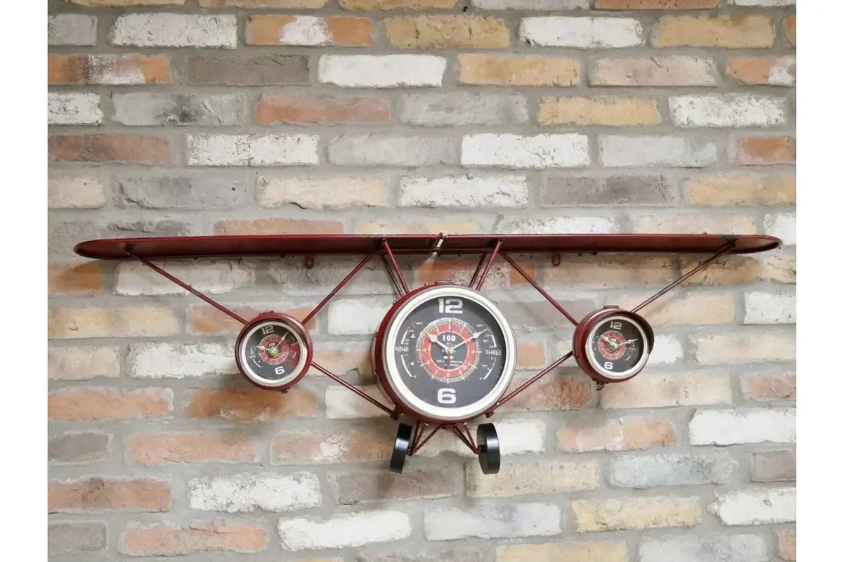 Vintage airplane wall clock with three dials and metal wing on brick background