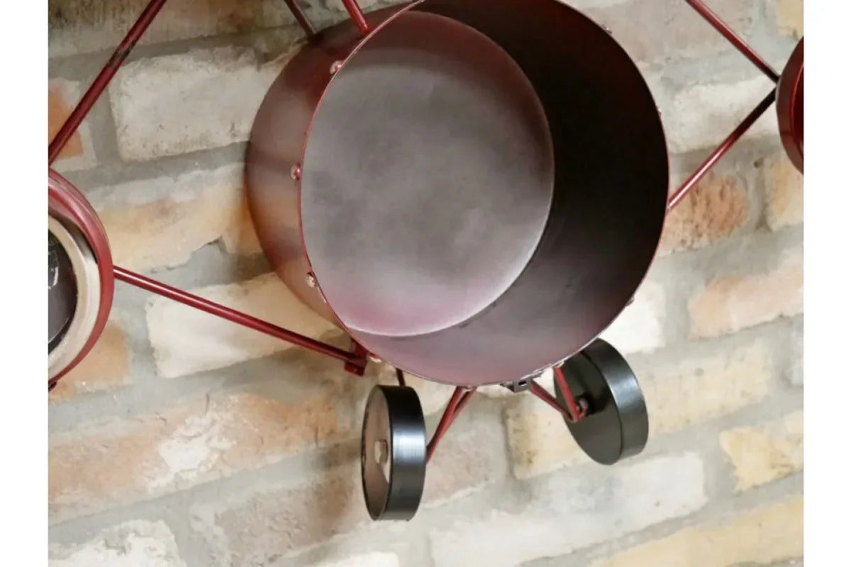 Red metal wall art shaped like an airplane against a brick wall