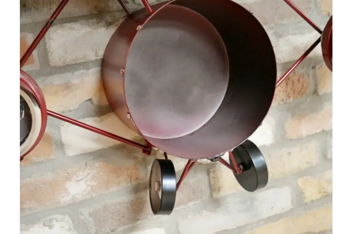 Red metal wall planter with round pot and wheels mounted on brick wall