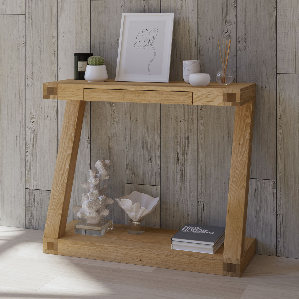 Oak console table with shelf, decorated with framed art, plants, coral and books