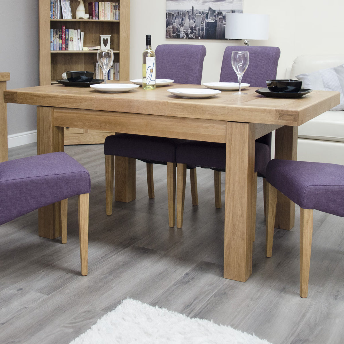Oak dining table set with purple fabric chairs on grey wood floor
